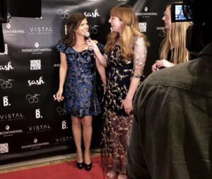 Two women are talking to each other on the red carpet.