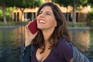 A woman holding onto her phone and smiling.